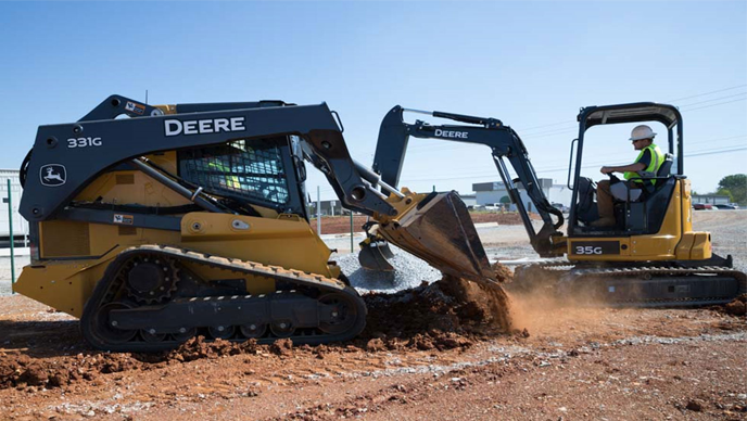 A 331G scoops gravel in the foreground on a work site in Hunstville, Alabama while a 35G works in the background. 